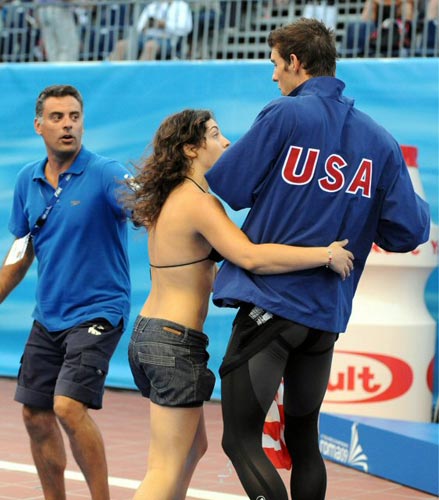 2일(현지시간) 이탈리아 로마 포로 이탈리코 수영장에서 열린 국제수영연맹(FINA) 2009 세계수영선수권, 미국의 수영 황제 마이클 펠프스가 남자 4x100m 혼계영 금메달을 받기 위해 시상대로 가던 중 한 여성팬이 나타나 포옹을 하고 있다. 
