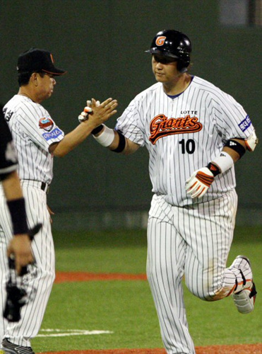 4일 경남 마산야구장에서 열린 2009 프로야구 롯데와 두산전.8회말 1사 1루 때 롯데 이대호가 투런 홈런을 날린 뒤 3루 코치와 하이파이브를 하고 있다.
 