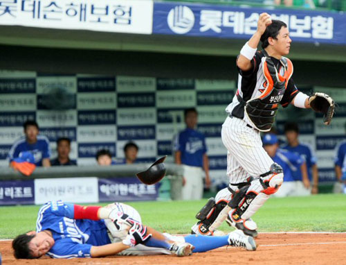    9일 부산 사직야구장에서 열린 프로야구 롯데와 삼성의 경기. 3회초 무사 1루에서 박한이의 중전 2루타때 1루에 있던 조동찬이 홈에 들어오다 롯데 최기문과 헬멧과 포수 마스크가 벗겨지는 치열한 접전을 벌인 끝에 삼성 조동찬은 태그아웃 당하고 있다. 최기문이 심판 판정 후 손을 치켜들고 있다. 