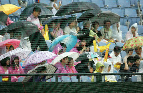 11일 광주 무등경기장에서 열린 2009 프로야구 기아 타이거즈와 롯데 자이언츠의 경기가 우천으로 중단되고 있는 가운데 관중들이 떠나지 않고 경기 재개를 기다리고 있다. 