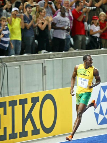 16일(현지시간) 독일 베를린 올림피아 슈타디온에서 열린 2009 세계육상 선수권 남자 100m 결승, 자메이카의 우사인 볼트가 9초58의 세계신기록으로 우승한 후 관중들의 환호 속에 기뻐하고 있다. 