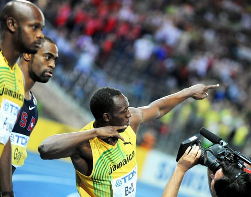 16일(현지시간) 독일 베를린 올림피아 슈타디온에서 열린 2009 세계육상 선수권 남자 100m 결승, 자메이카의 우사인 볼트가 9초58의 세계신기록으로 우승한 후 경쟁자인 아사파 파월(자메이카 / 왼쪽), 타이슨 게이(미국 / 왼쪽 두번째)가 지켜보는 가운데 세리머니를 펼치고 있다. 