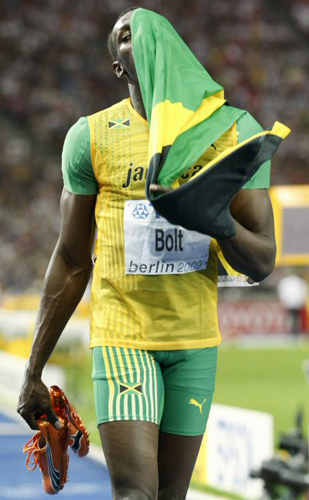 ‘인간 탄환’ 우사인 볼트(자메이카)가 20일(현지시간) 독일 베를린에서 열린 세계육상선수권대회 남자 200m에서 세계 신기록을 달성한 뒤 국기로 얼굴을 감싸고 있다. 