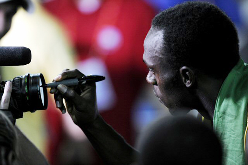 22일(현지시간) 독일 베를린에서 열린 2009 세계육상선수권대회 남자 400m 계주에서 우승한 자메이카의 우사인 볼트가 카메라 렌즈에 사인을 하고 있다. 