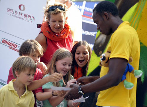 24일(한국시간) 2009 IAAF(국제육상경기연맹) 세계 육상선수권 대회에서 3관왕에 오른 자메이카의 ‘육상 황제’ 우사인 볼트가 어린 팬들에게 사인을 해 주고 있다. 