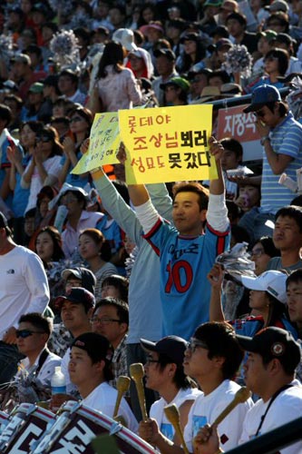 3일 부산 사직야구장에서 열린 2009 프로야구 준플레이오프 4차전 롯데 자이언츠-두산 베어스 경기, 한 롯데팬이 성묘도 못갔다는 글을 들고 응원을 하고 있다. 