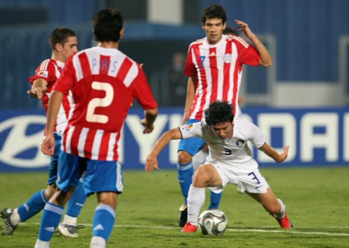 6일 새벽(한국시간) 이집트 카이로 스타디움에서 열린 2009 국제축구연맹(FIFA) 20세 이하(U-20) 월드컵 16강전 대한민국-파라과이 경기, 한국 김민우가 상대 선수들 사이에서 돌파를 시도하다 넘어지고 있다. 