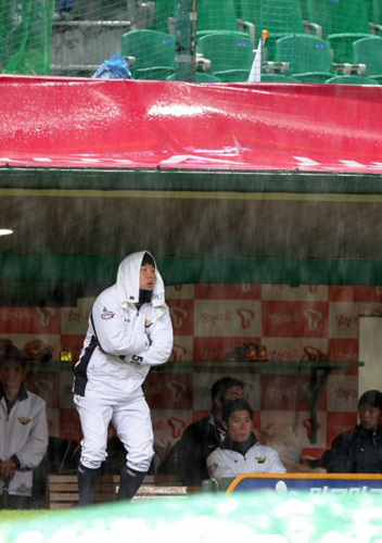 13일 인천 문학구장에서 열린 프로야구 플레이오프 5차전 SK와이번스-두산베어스 2회초 솔로 홈런을 때린 두산 김현수와 동료들이 폭우로 경기가 중단되자 더그아웃에서 비를 바라보고 있다. 