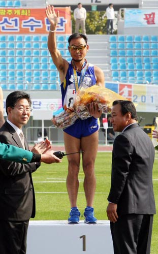 충남 대표로 참가한 국민마라토너 이봉주가 21일 대전 한밭종합운동장에서 열린 제90회 전국체전 남자일반부 마라톤에서 1위로 골인한 후 금메달을 목에 걸고있다. 