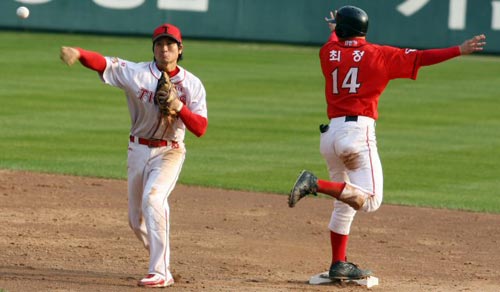 24일 서울 잠실구장에서 열린 2009 프로야구 한국시리즈 7차전 기아 타이거즈-SK 와이번스 경기, SK 최정(오른쪽)이 5회초 무사 1루 상황에서 조동화의 보내기 번트 때 기아 투수 한기주가 2루로 송구한 사이 세이프 되고 있다. 