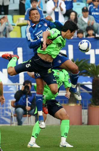  24일 수원월드컵경기장에서 열린 프로축구 2009 K리그 전북 현대와 수원 삼성의 경기에서 수원 티아고(위)와 전북 손승준이 볼 다툼을 벌이고 있다. 