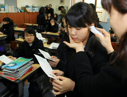  대학수학능력시험을 하루 앞둔 11일 서울 배화여고에서 학생들이 담임교사로부터 발열검사를 받으며 수험표를 받고 있다. 