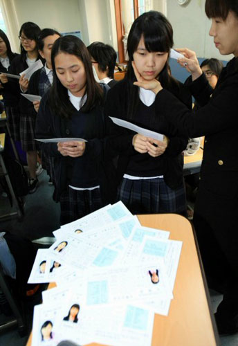 대학수학능력시험을 하루 앞둔 11일 서울 배화여고에서 학생들이 담임교사로부터 발열검사를 받으며 수험표를 받고 있다. 