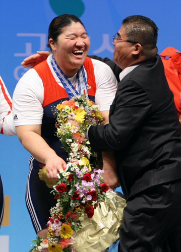 장미란이 28일 경기 고양시 킨텍스 역도경기장에서 열린 2009세계역도선수권대회 여자부 최중량급(+75kg) 경기에서 용상 187kg을 들어올리고 세계신기록을 작성한 뒤 아버지 장호철씨와 포웅을 하고 있다. 